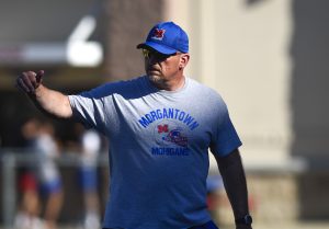 Morgantown High head football coach Sean Biser draws up more than just gridiron strategy